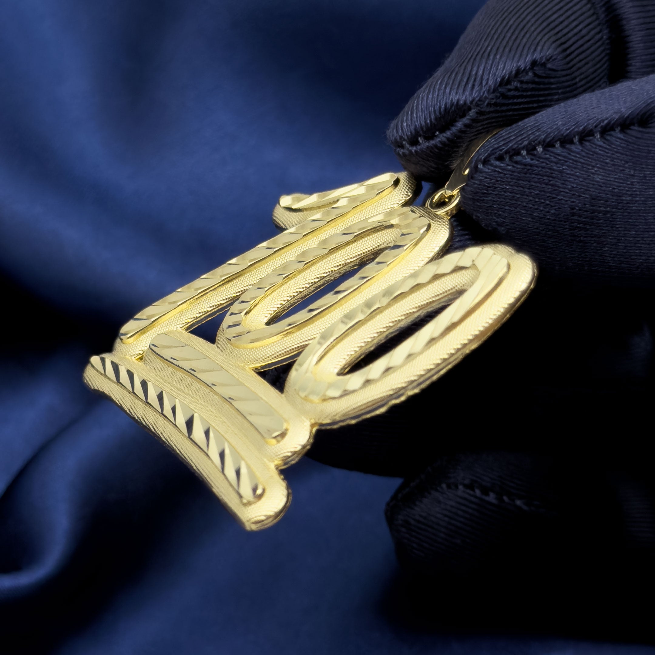 10k Yellow Gold 100 Emoji Symbol Pendant with Diamond Cuts on blue background side view