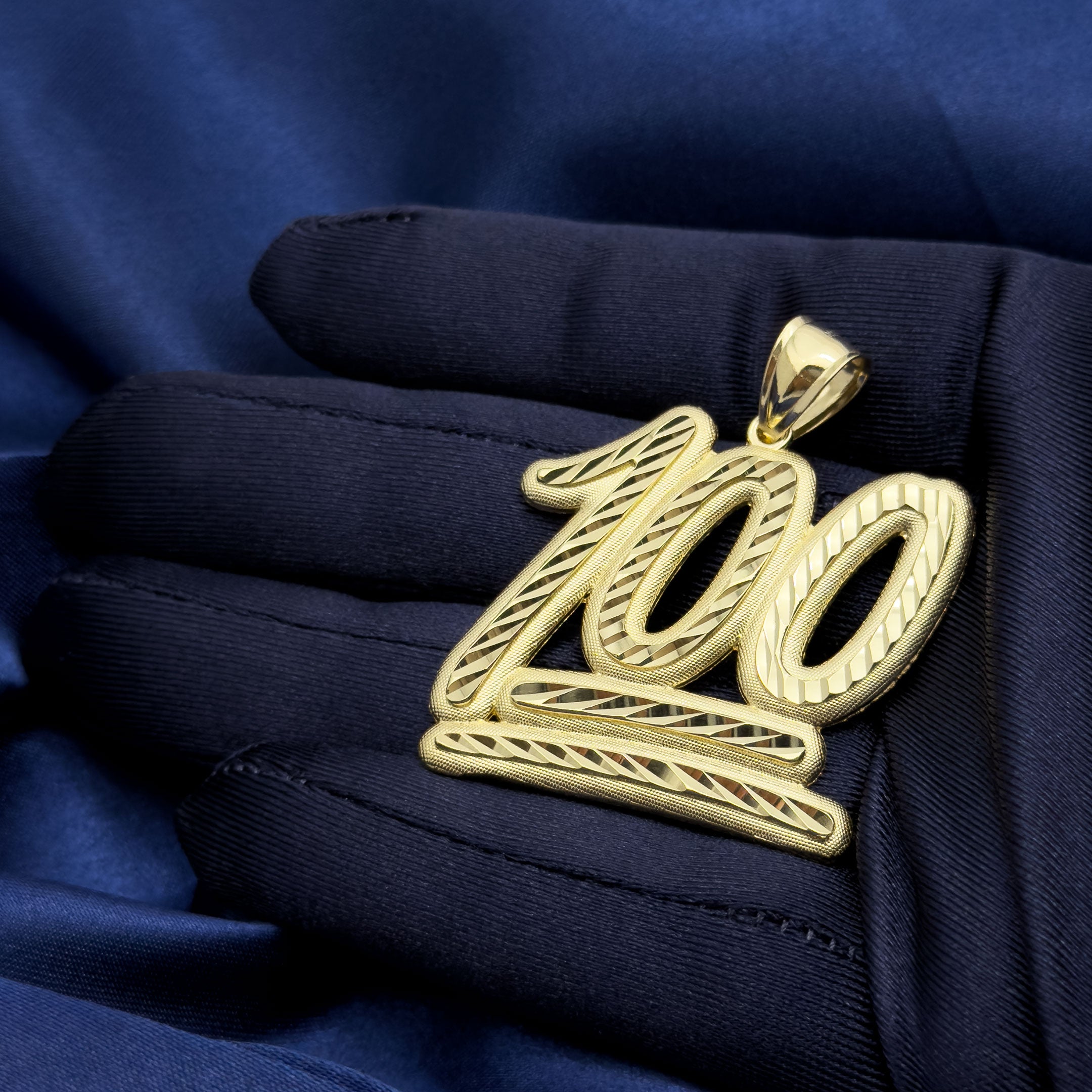 10k Yellow Gold 100 Emoji Symbol Pendant with Diamond Cuts on blue background in hand