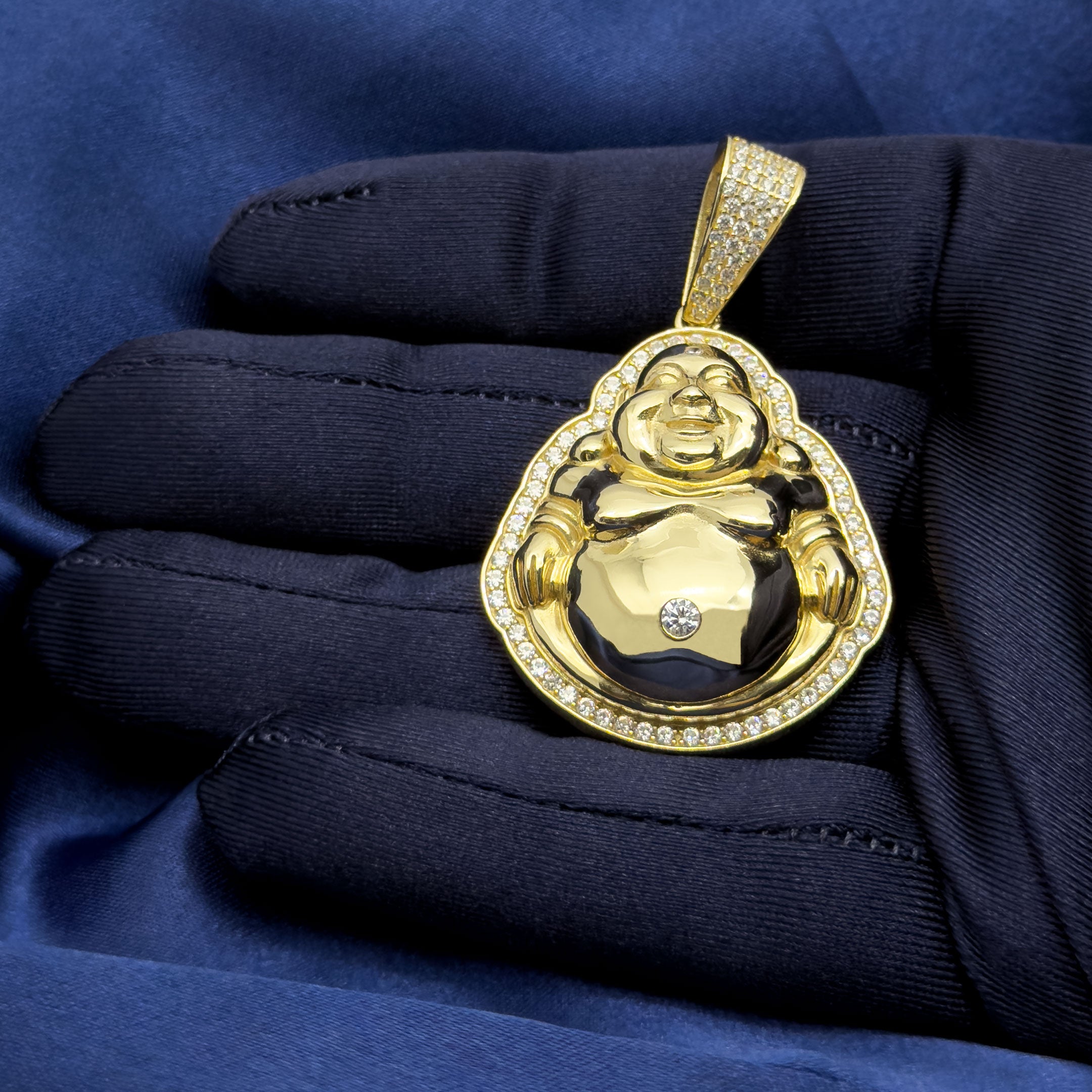 14k Yellow Gold Happy Buddha Pendant with CZ Stones on blue background in hand