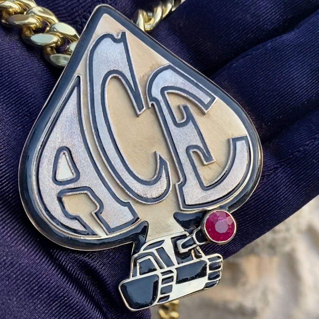 Metallic badge with 'ACE' letters on a blue fabric background