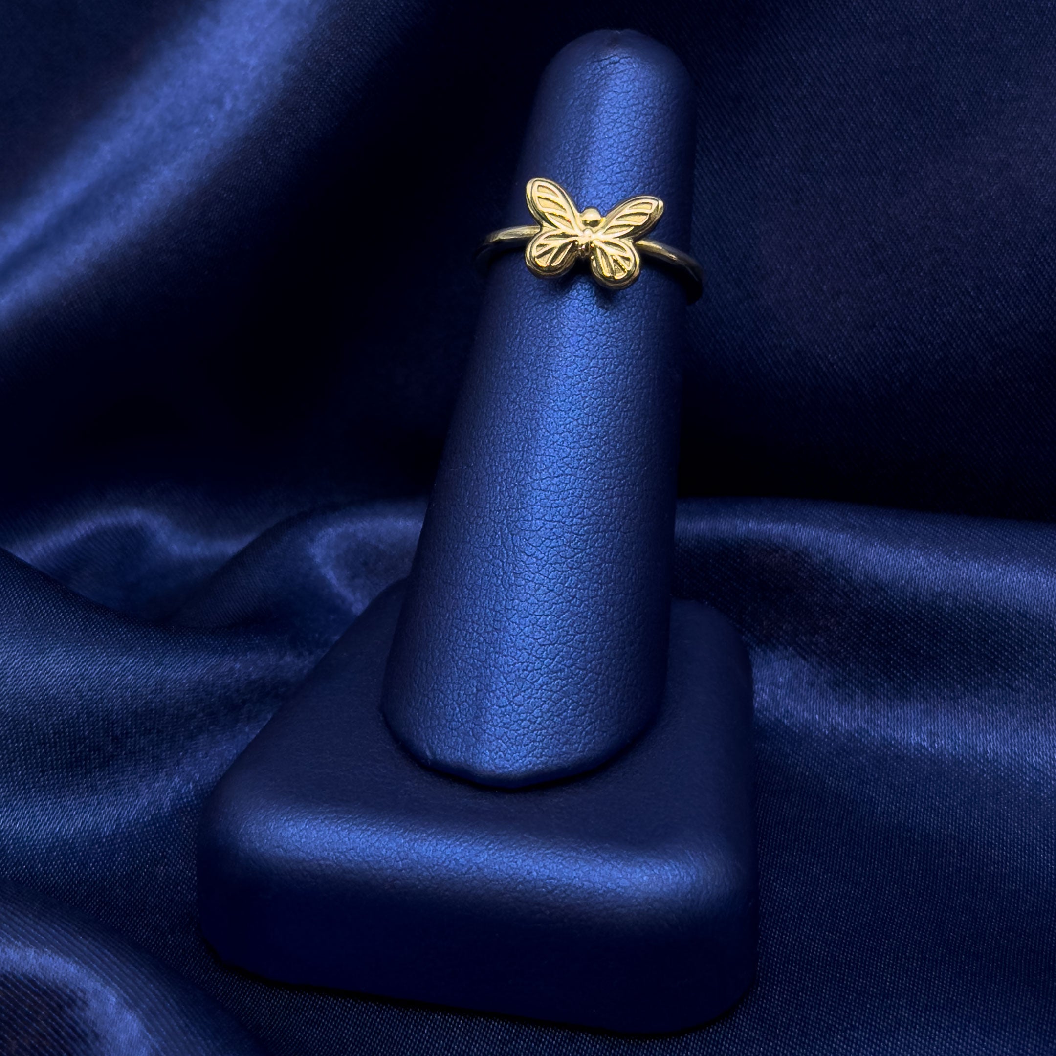 10k Gold Butterfly Ring on a Blue Finger Display with Blue Background