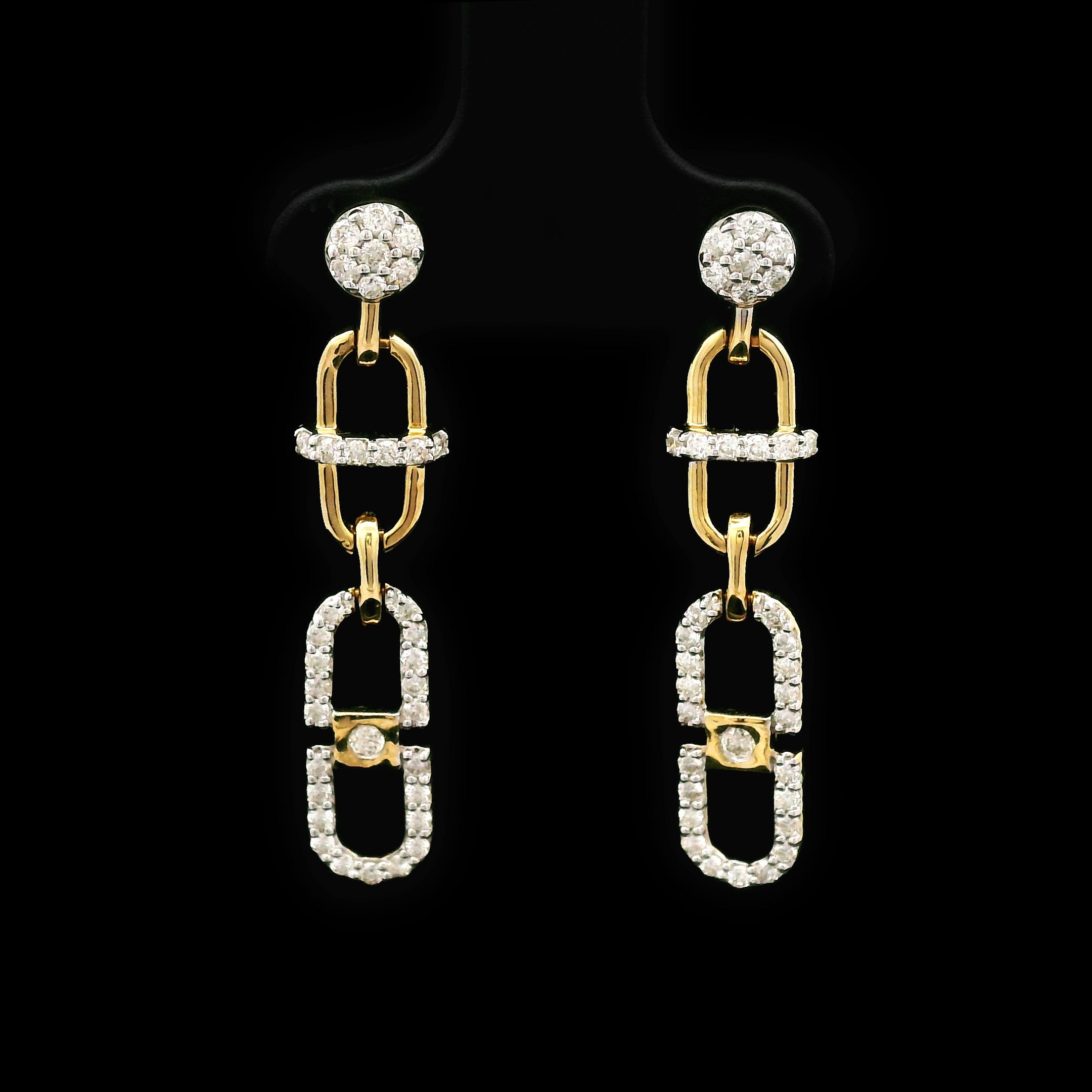 Pair of 14k gold and diamond earrings on a black background with cable design