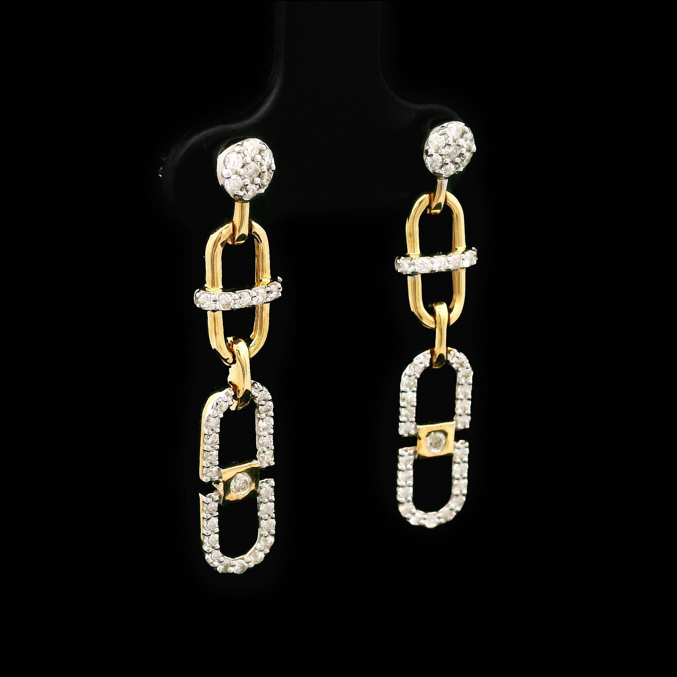 Pair of 14k gold and diamond earrings on a black background with cable design left