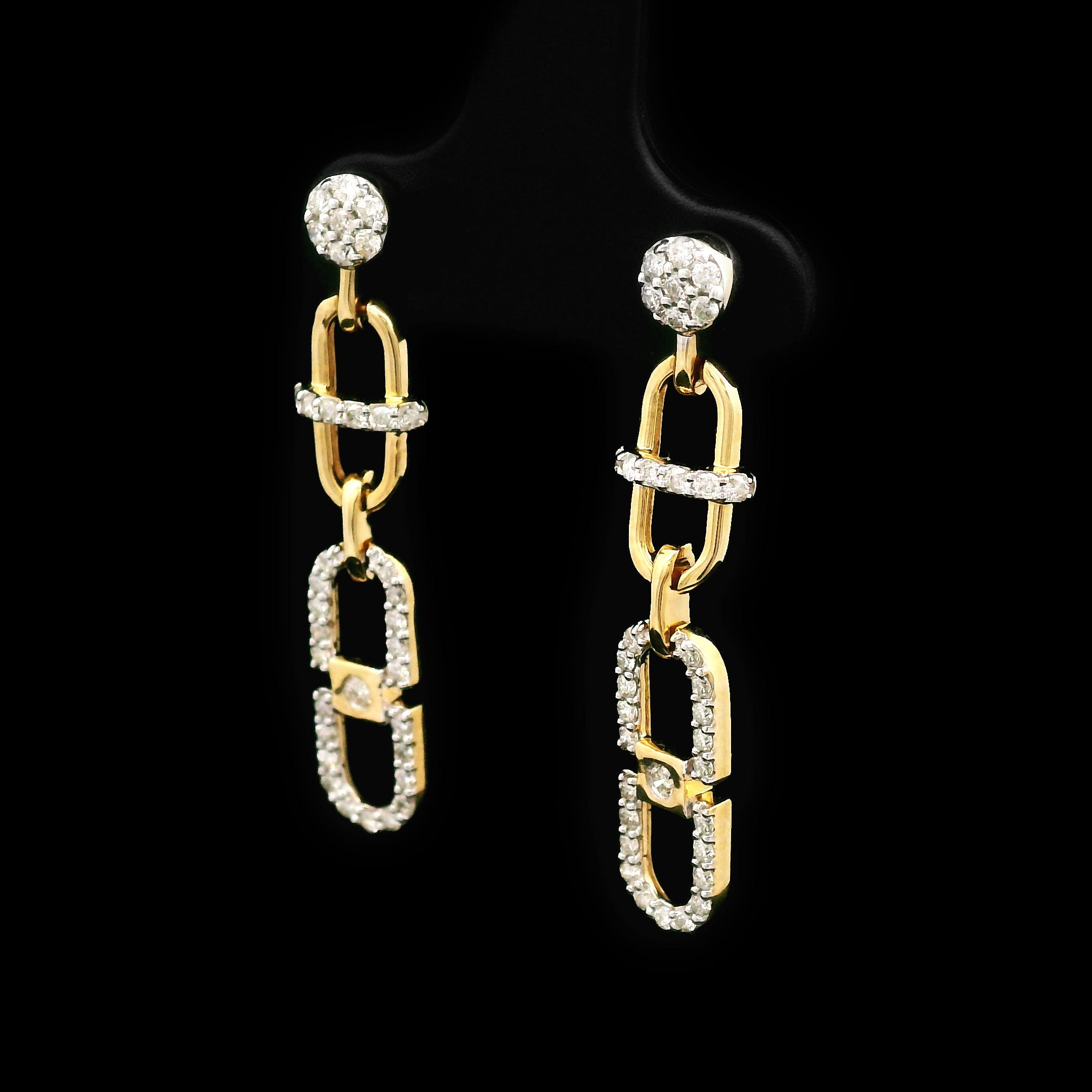 Pair of 14k gold and diamond earrings on a black background with cable design right