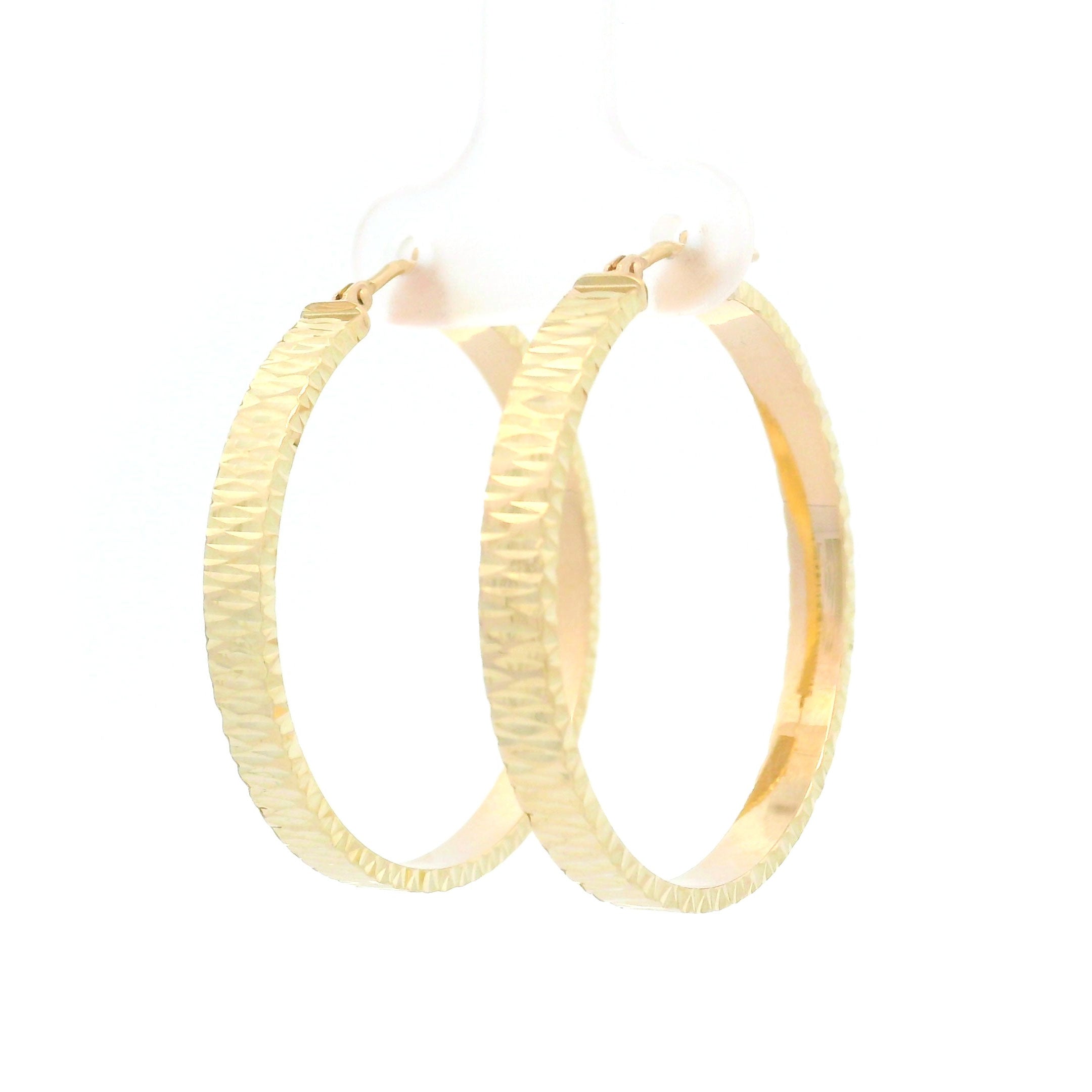 Gold diamond cut hoop earrings on a white background