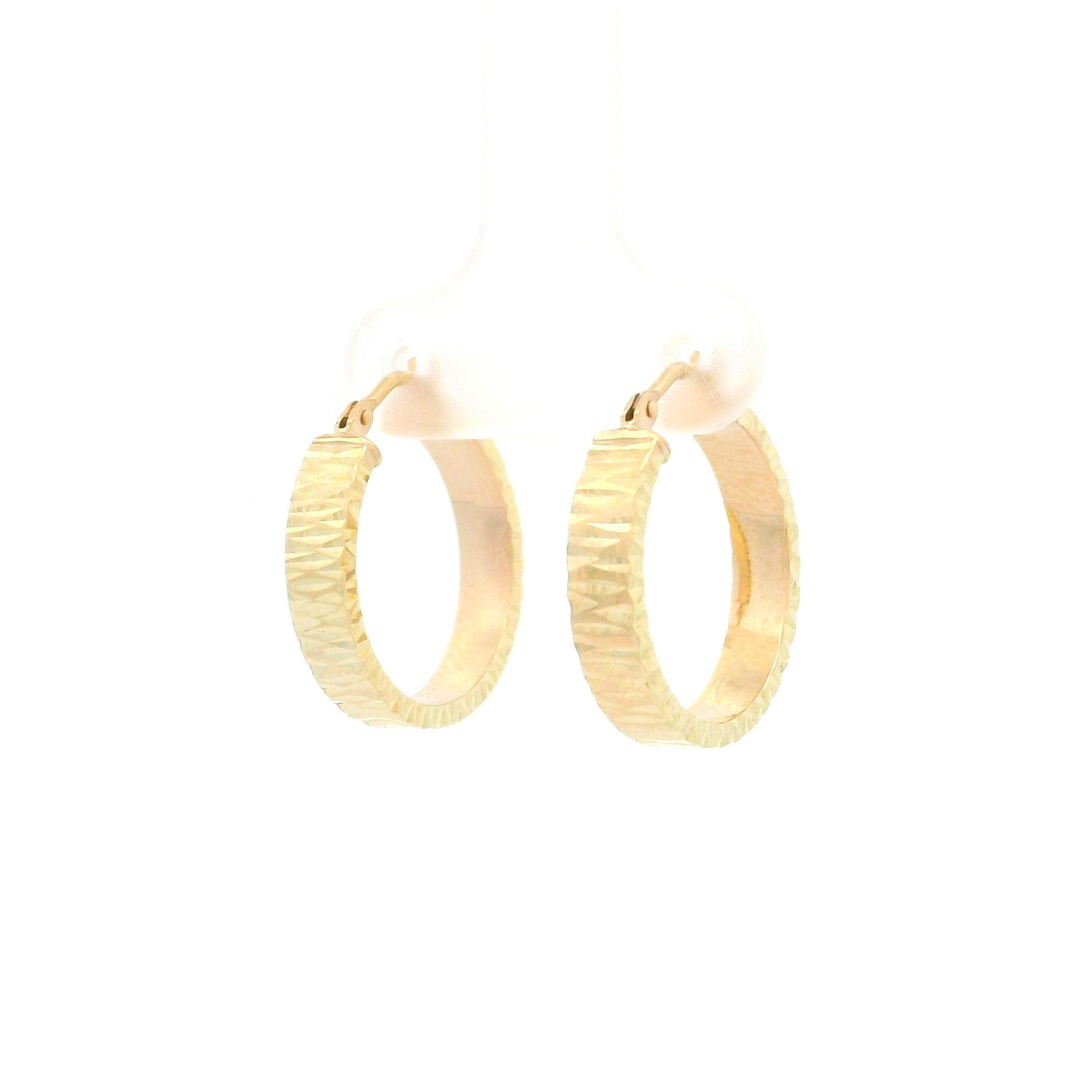 Gold diamond cut hoop earrings on a white background