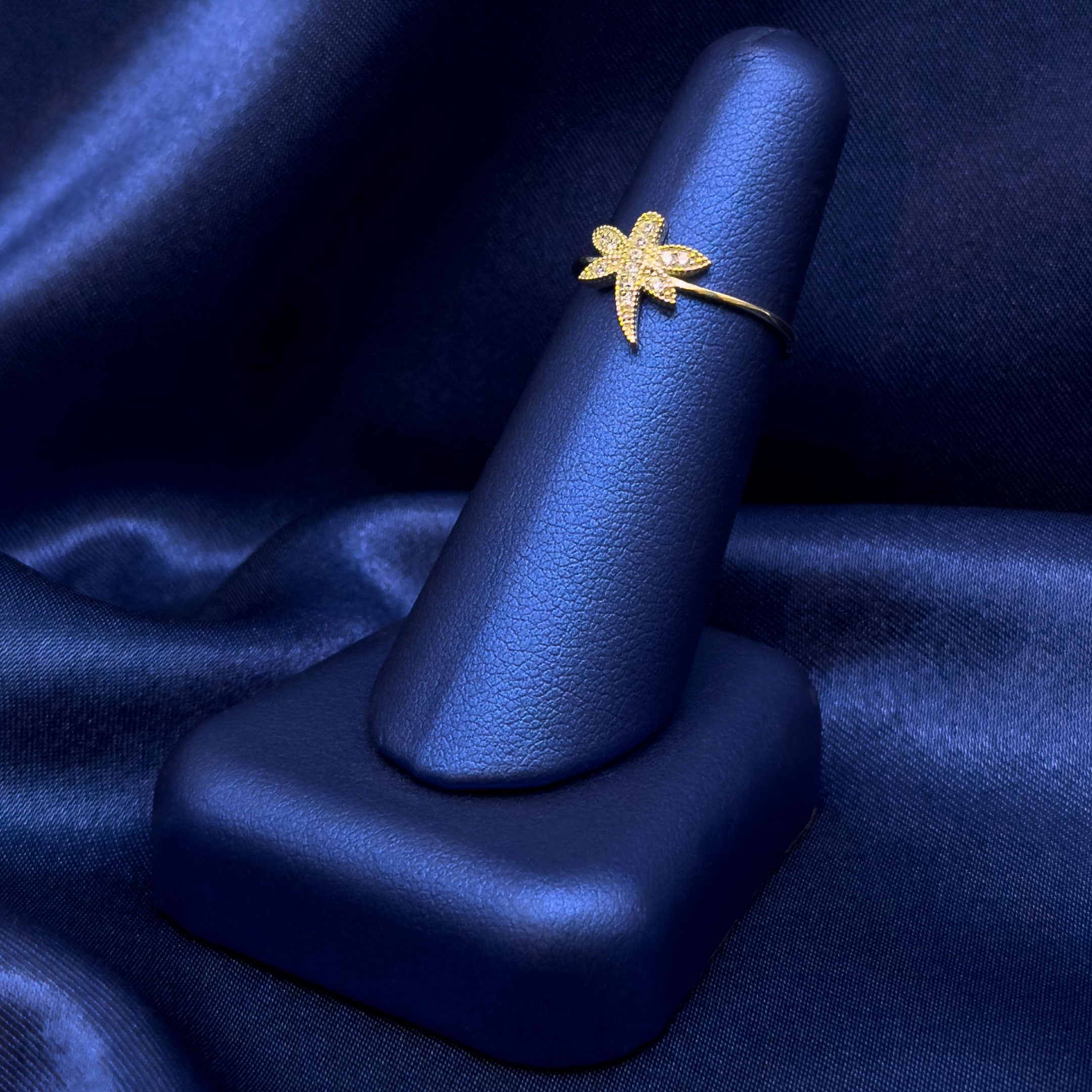 10k Gold CZ Dragonfly Ring on a blue satin background