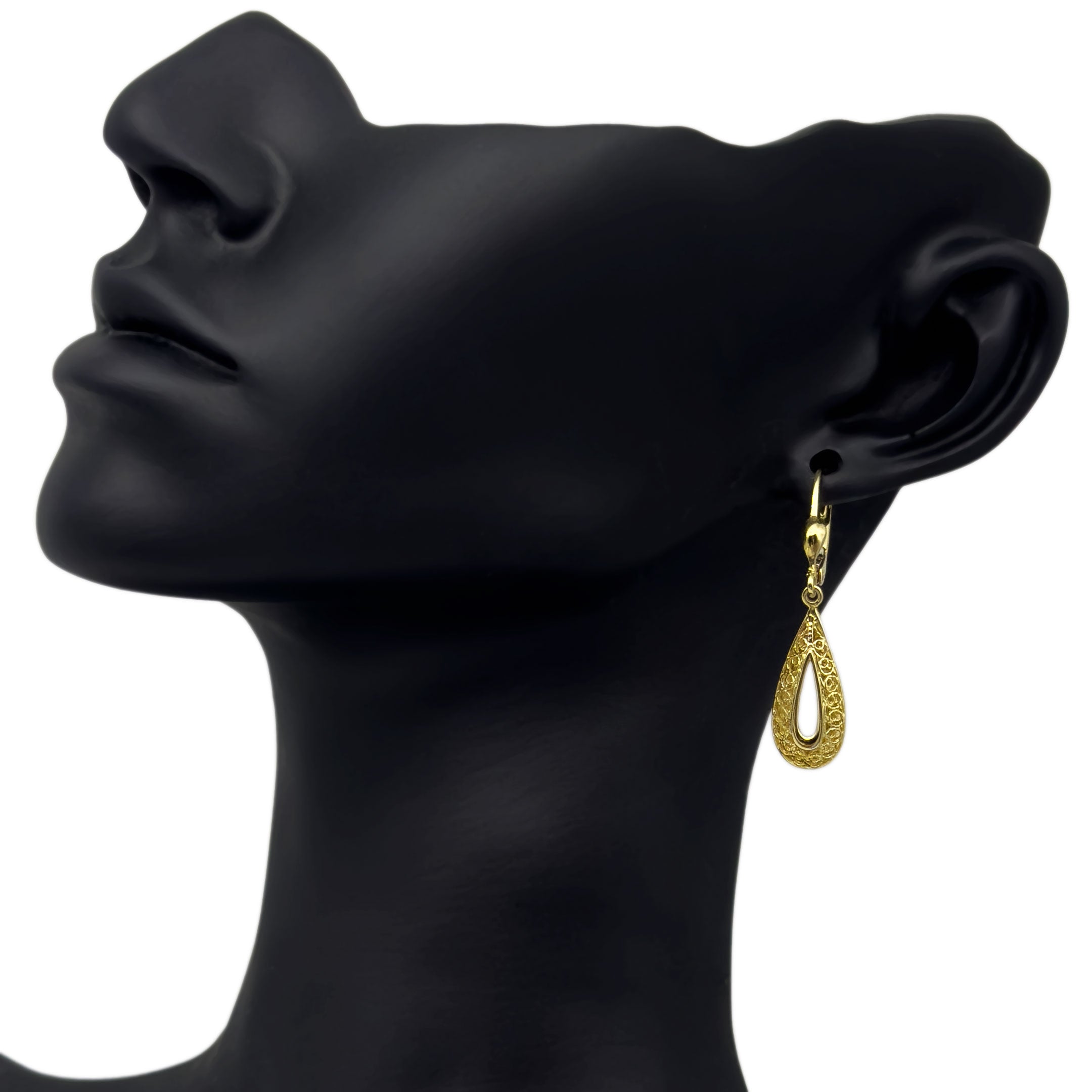 Gold teardrop earring on a black mannequin head