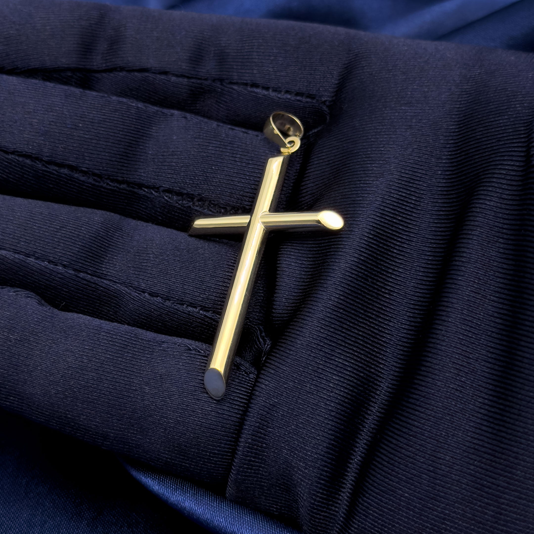 10k yellow gold hollow polished cross pendant with angled edges on blue background