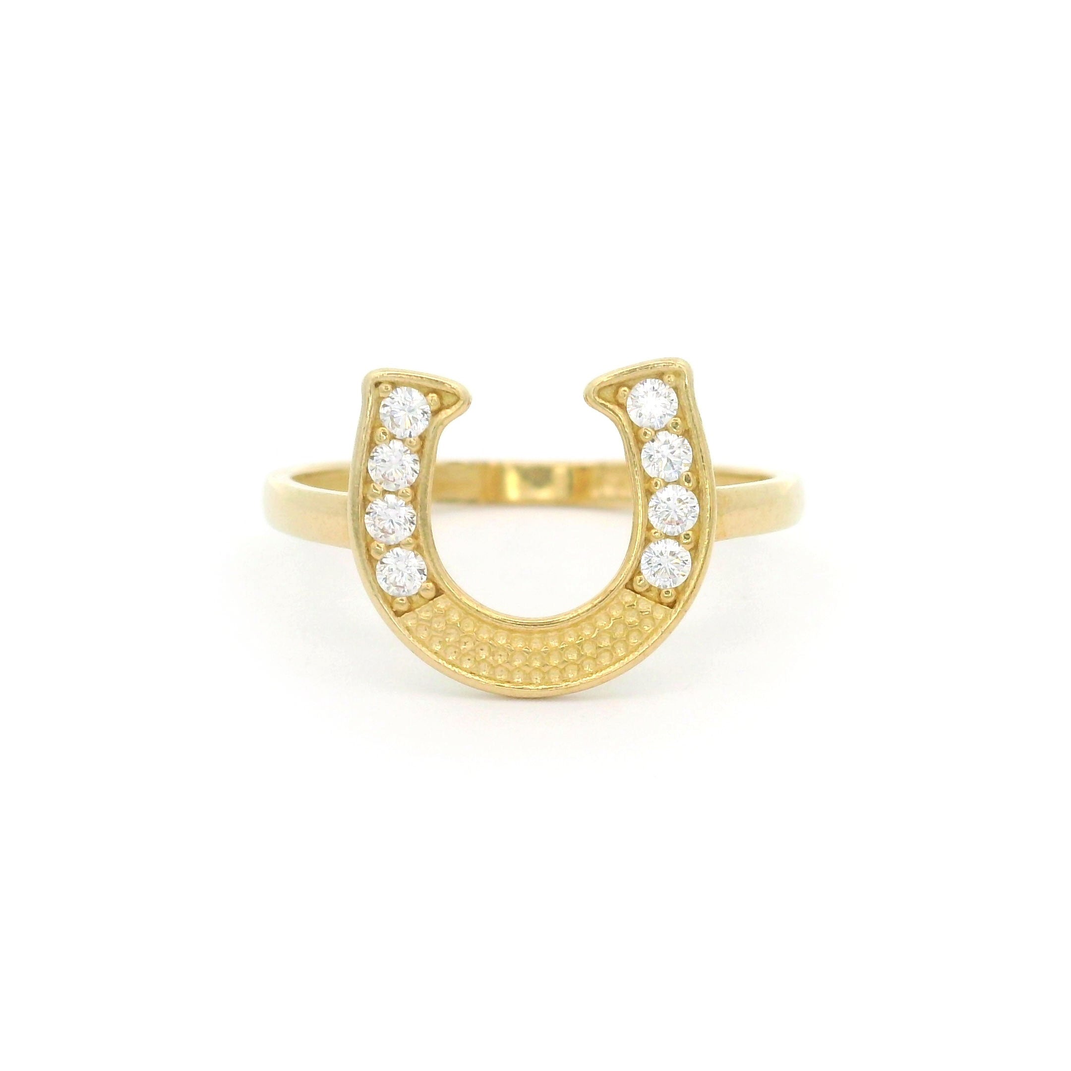 10k yellow gold horseshoe ring with stones on white background