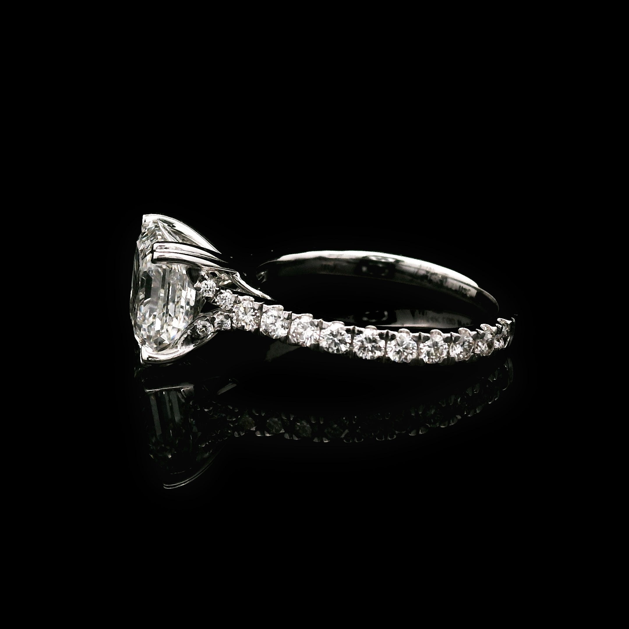 Diamond engagement ring with 3 carat Asscher cut center stone on a black background side