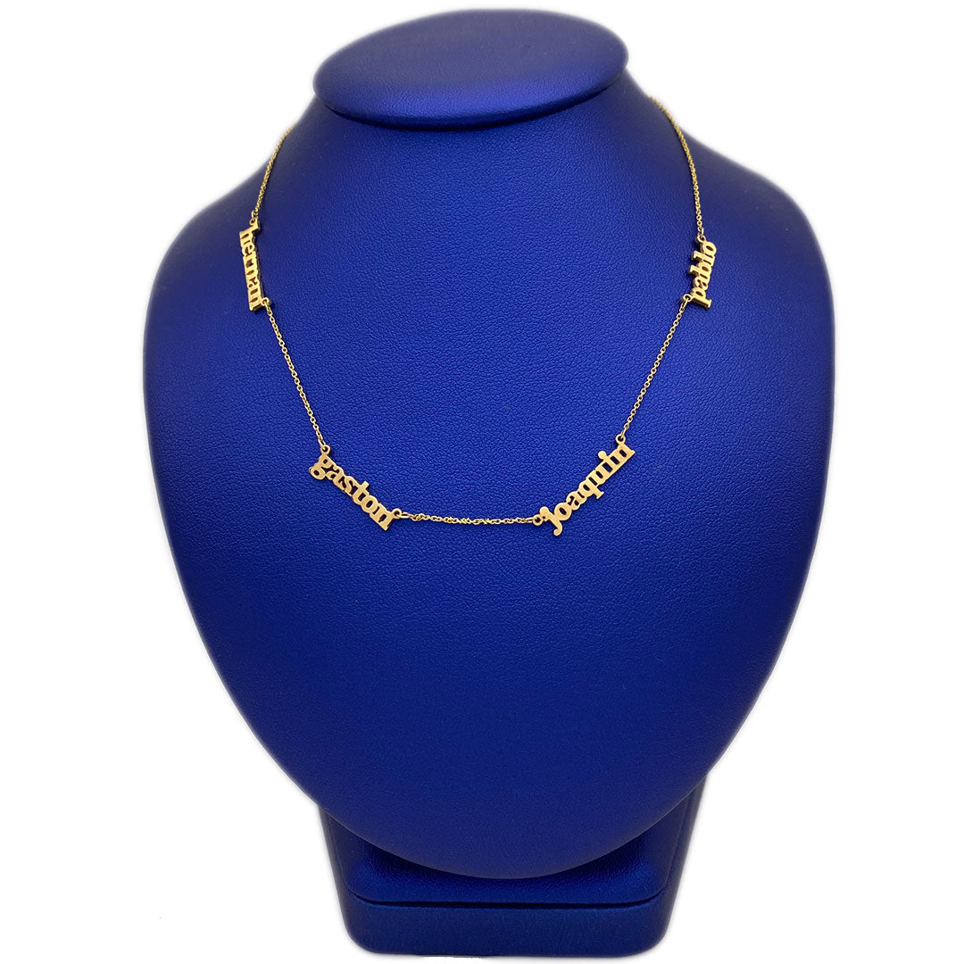 A 14k gold personalized necklace with multiple names engraved on it, displayed on a blue mannequin.