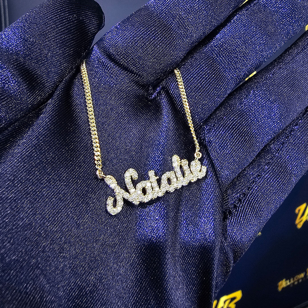 Personalized Natalie Diamond Script Sample Name Necklace in Gold in Hand with Navy Blue Glove