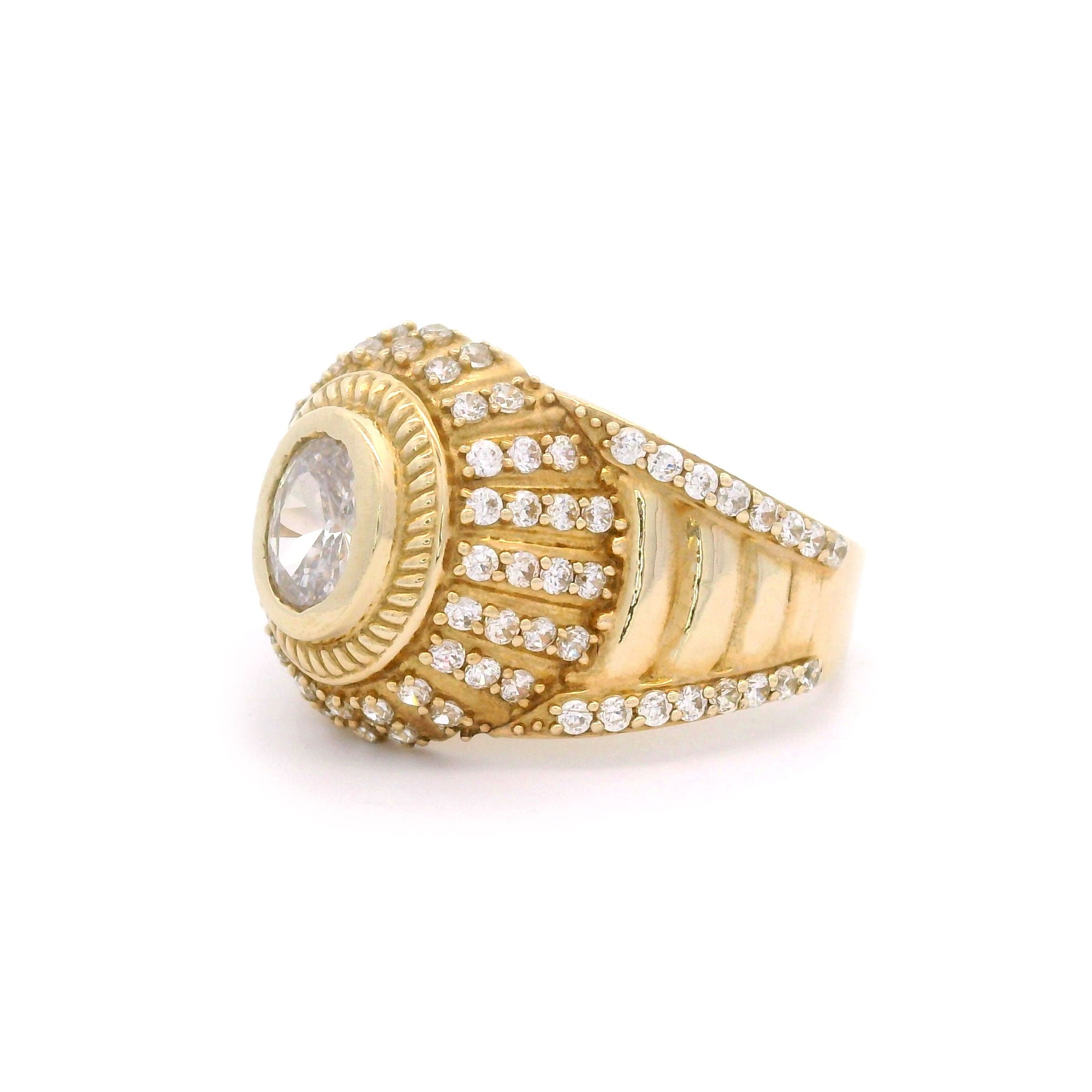 Oval gold ring with a central stone and smaller stones on a white background side