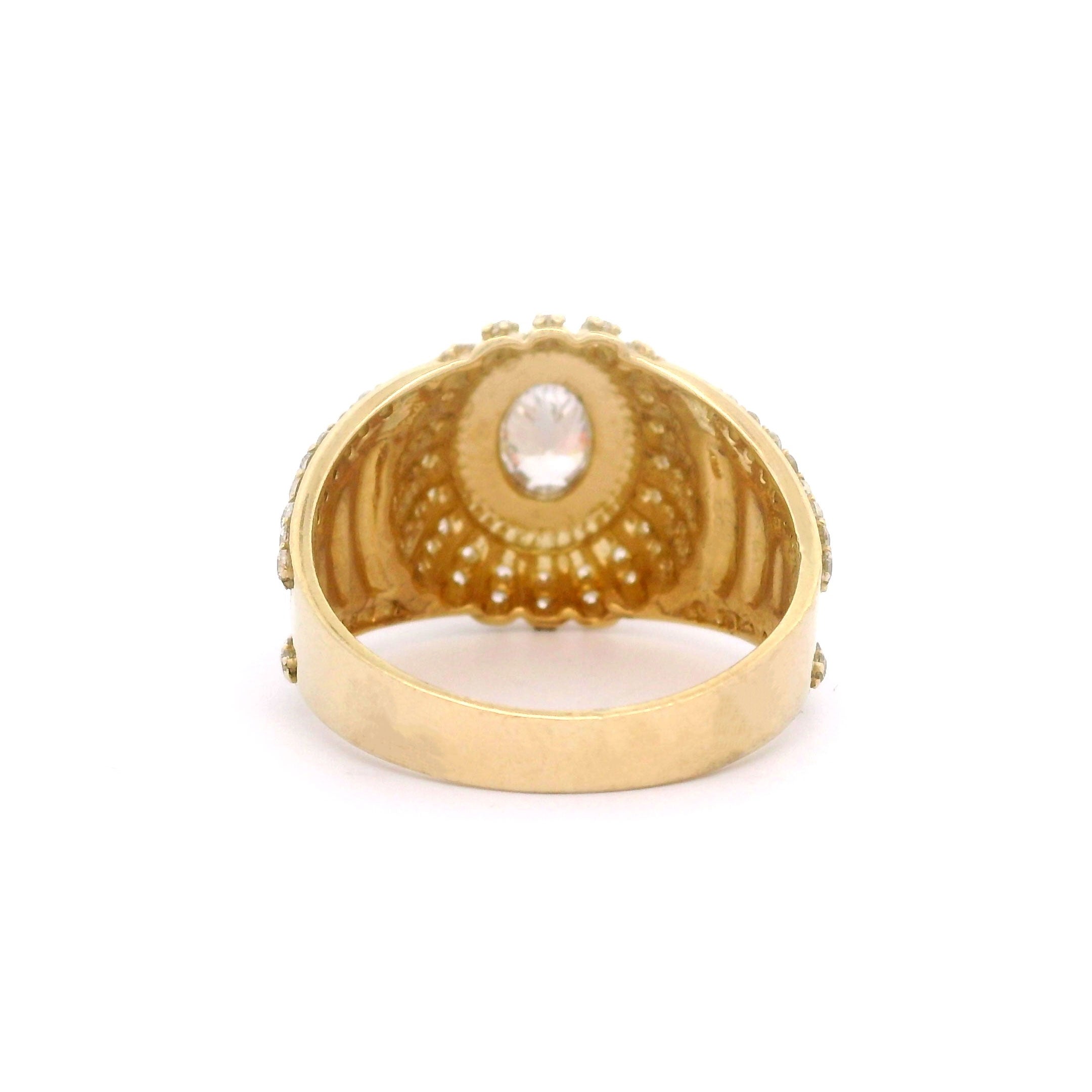 Oval gold ring with a central stone and smaller stones on a white background back