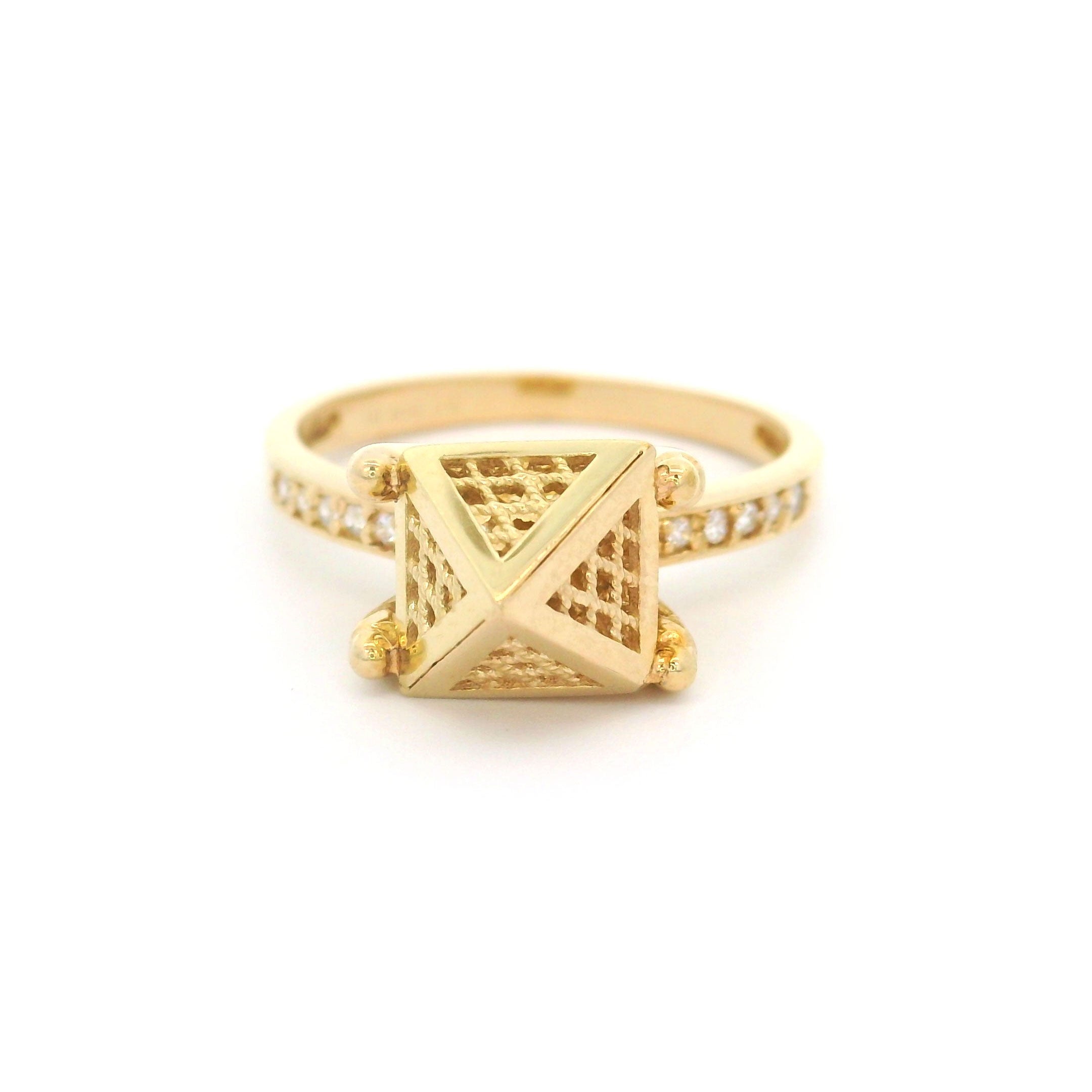 Gold ring with pyramid design on a white background