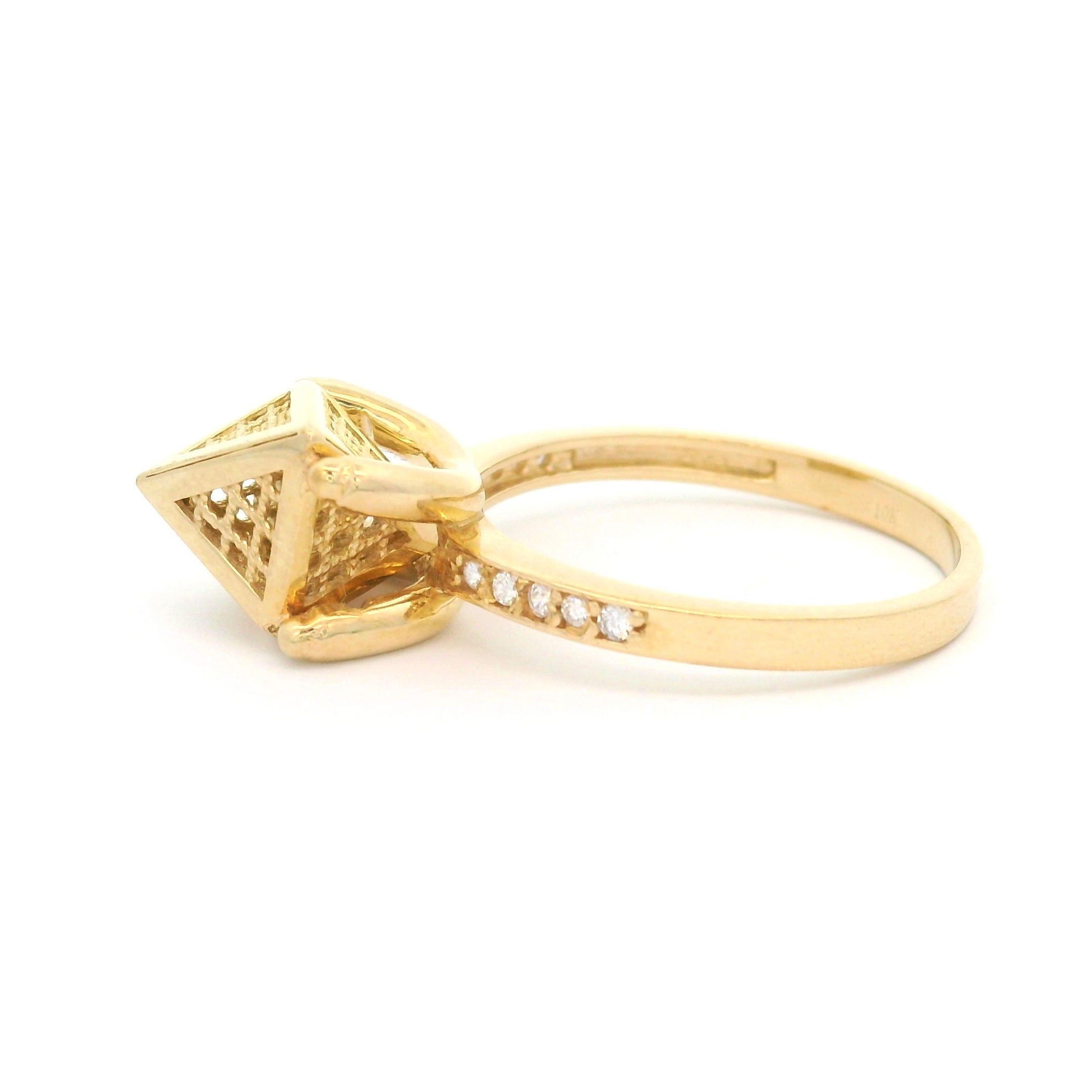 Gold ring with pyramid design on a white background side view