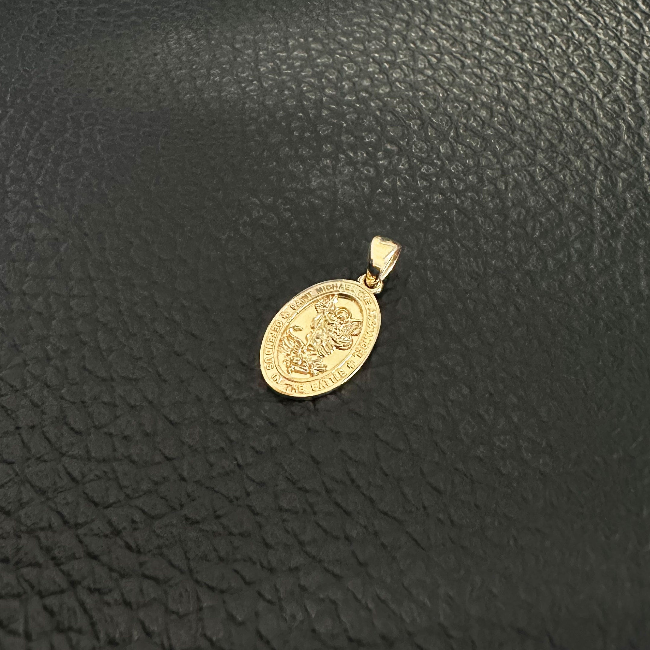 14k Saint Michael Mini Pendant in Yellow Gold on Textured Black Background