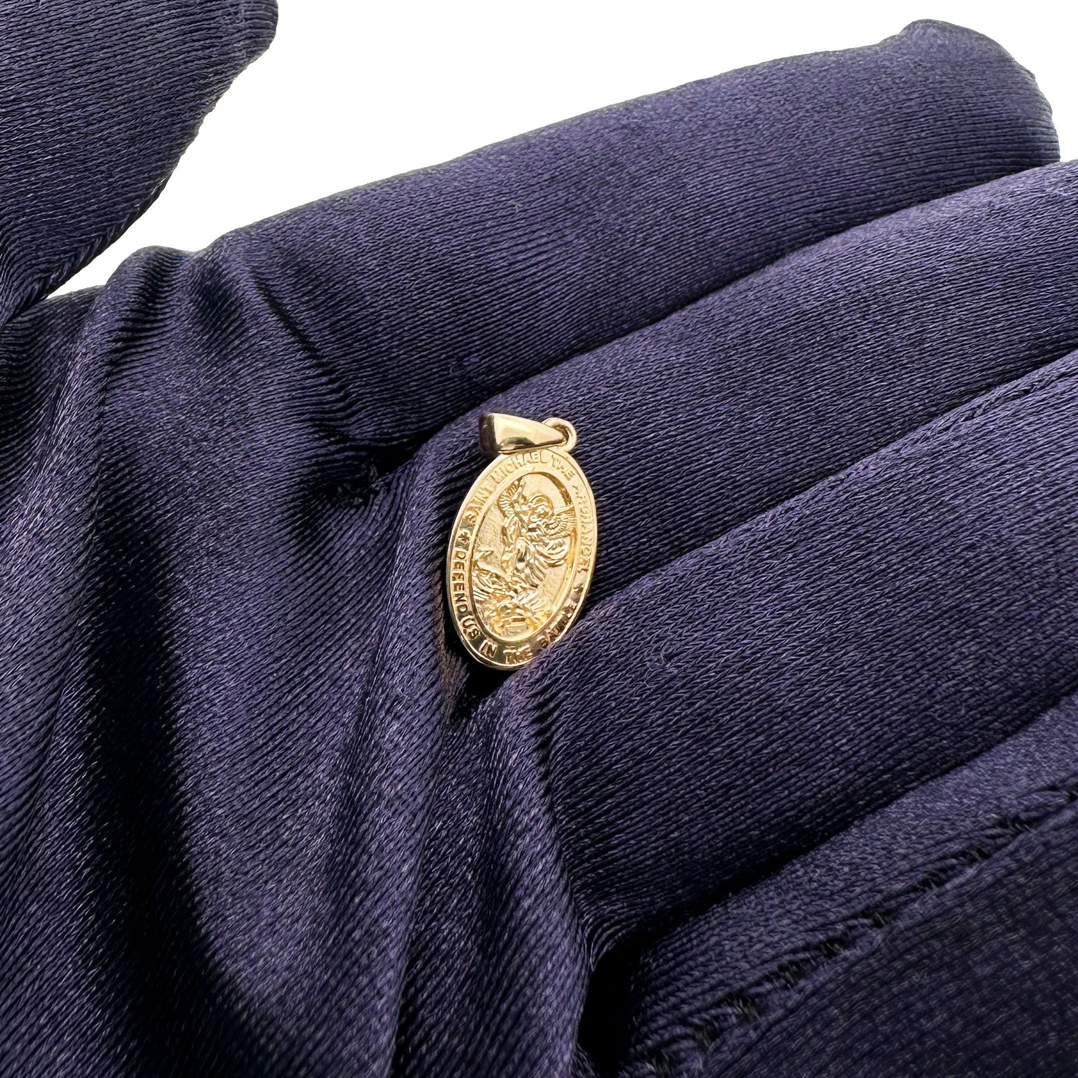 14k Saint Michael Mini Pendant in Yellow Gold in Hand with Blue Glove