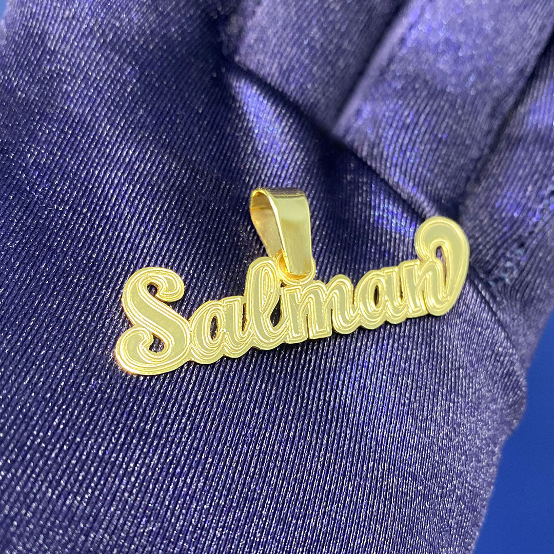 Gold 'Salman' pendant on a blue fabric background