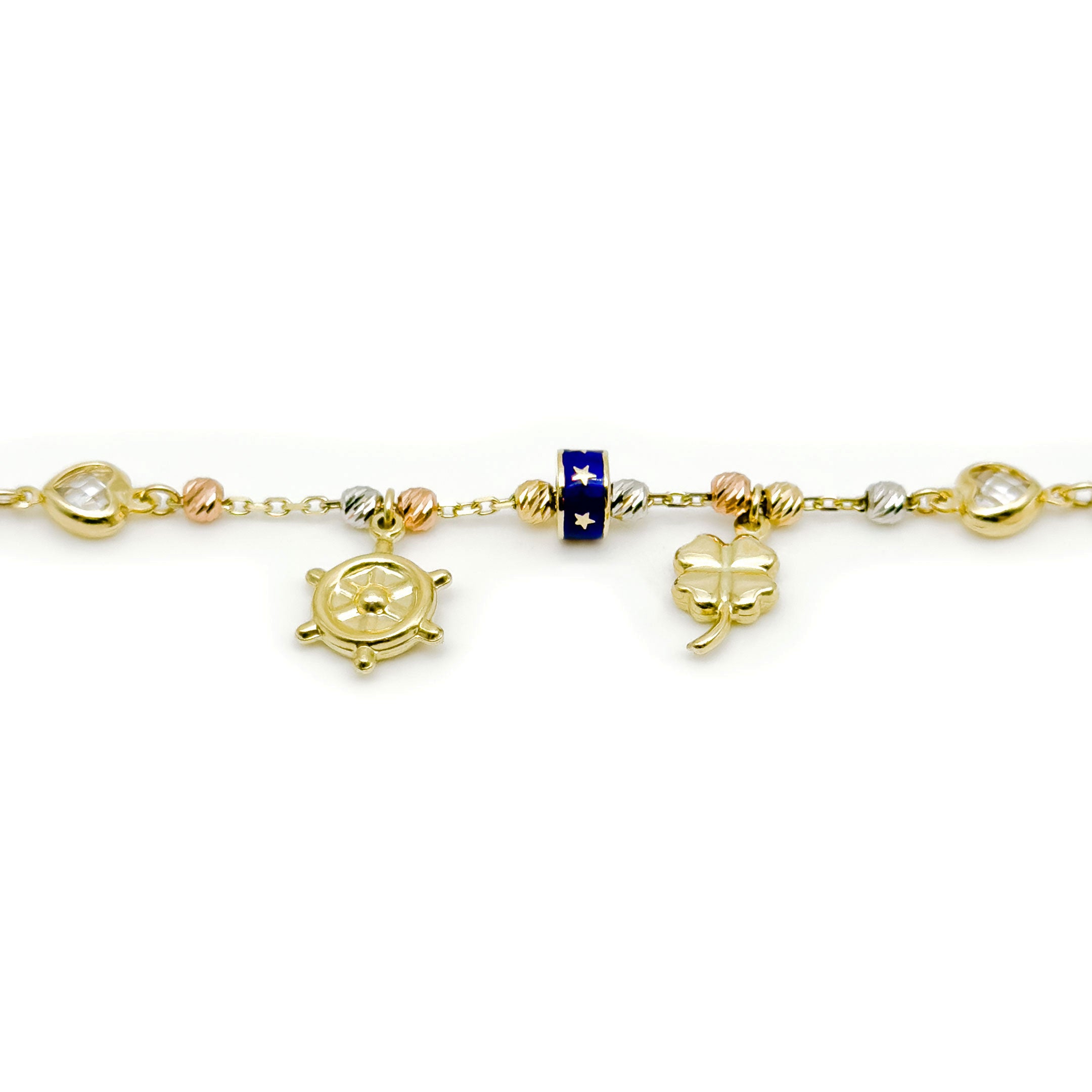 A gold charm bracelet with charms, including a ship's wheel, a four-leaf clover, a heart, and a blue and gold star-patterned bead, shown on a white background. close up of charms