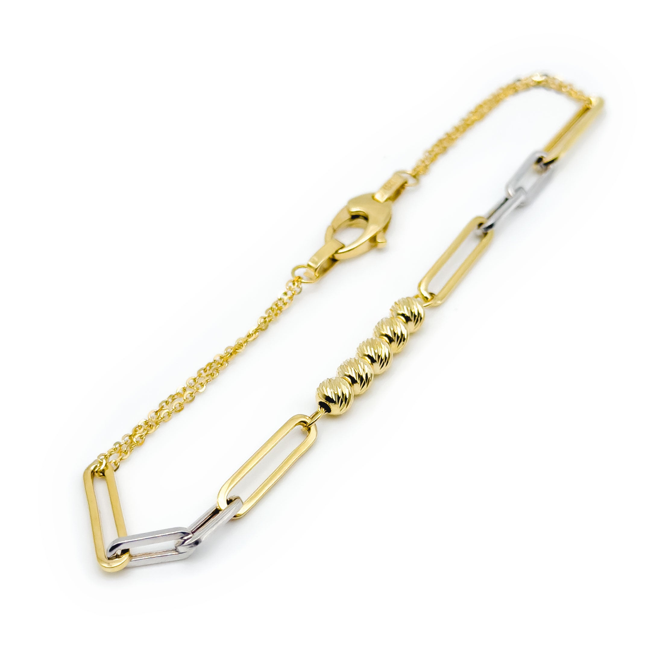 A delicate gold chain bracelet with alternating gold and white gold paperclip links and a central cluster of five textured gold beads, shown on a plain white background. close