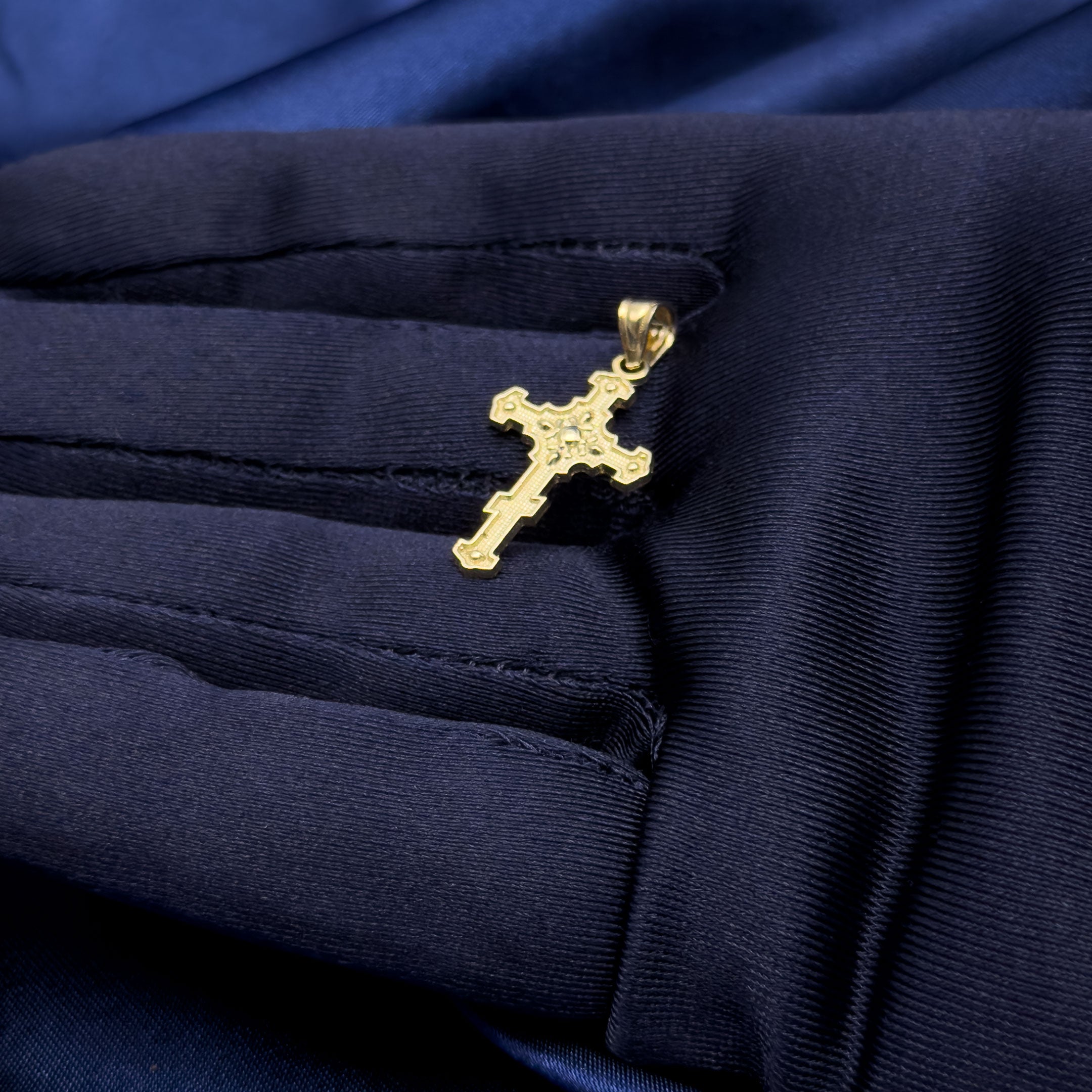 10k gold unique vintage style cross pendant in hand with blue glove