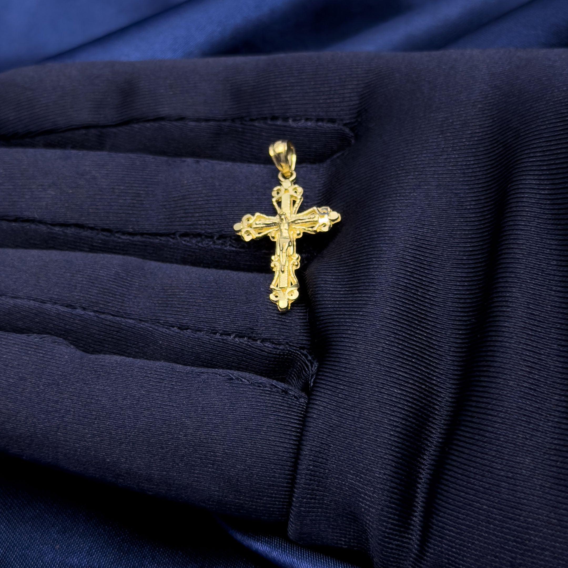 10k yellow gold vintage style crucifix cross pendant in hand with blue glove
