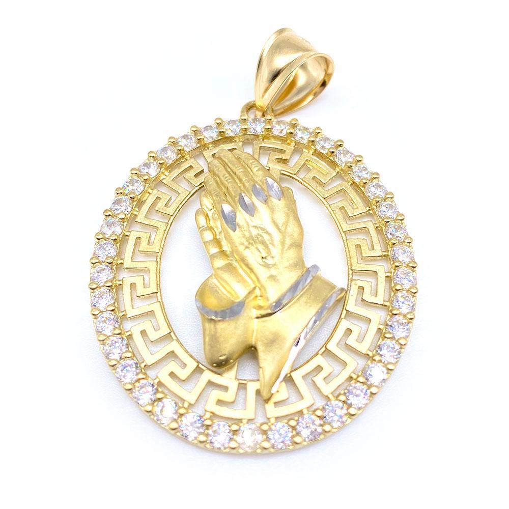 A 10k gold oval pendant featuring a cubic zirconia design of praying hands, surrounded by a geometric pattern.